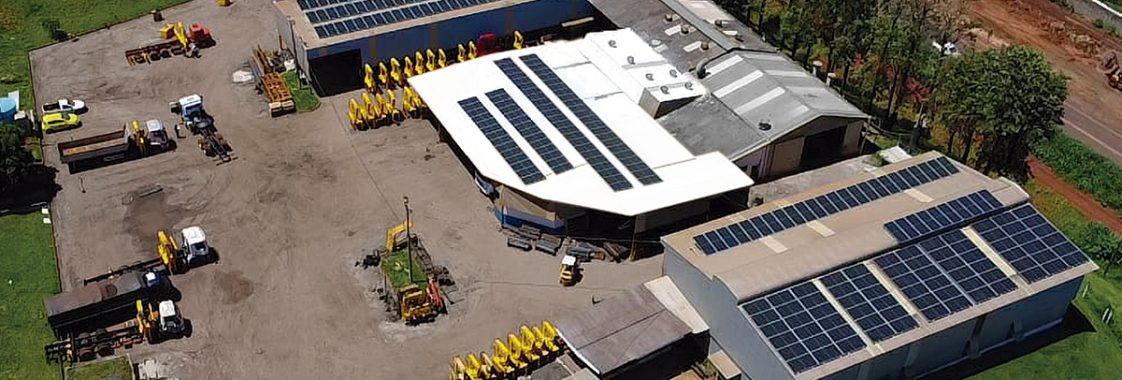 Vista aérea de fábrica de guindastes veiculares com equipamentos no pátio industrial, representando compra de guindaste direto do fabricante.