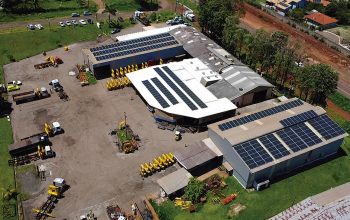 Vista aérea de fábrica de guindastes veiculares com equipamentos no pátio industrial, representando compra de guindaste direto do fabricante.