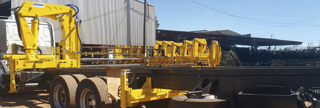 Guindaste articulado em caminhão em área industrial, equipamento usado em operações de içamento que exigem manutenção preventiva para manter desempenho e segurança.