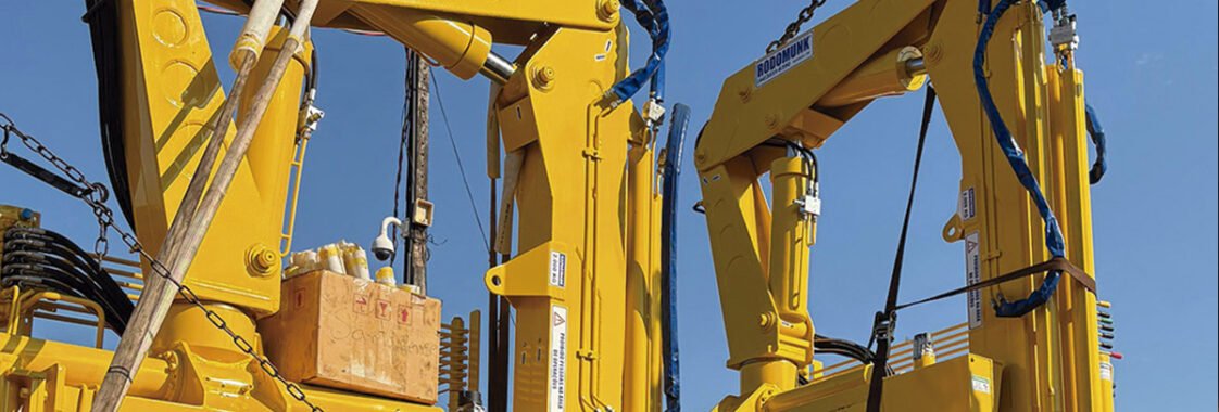 Guindastes veiculares articulados sendo montados em ambiente industrial, destacando a robustez estrutural, os braços hidráulicos e o acabamento industrial que reforçam a importância da qualidade de fabricação na escolha do fabricante.
